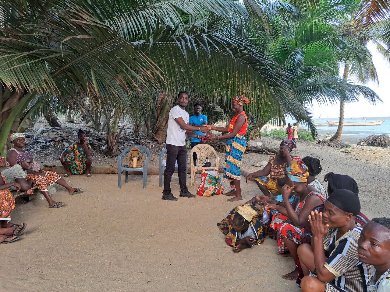 Dr Eric Krampa hands over safety gloves to Narkwa Oyster Harvesters